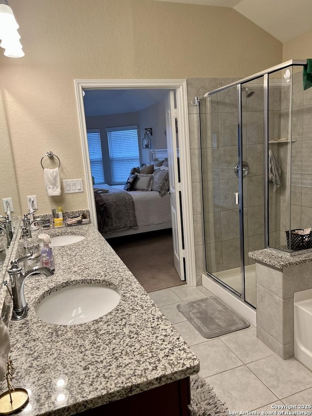 bathroom featuring lofted ceiling, vanity, tile patterned floors, and walk in shower