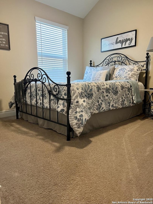 carpeted bedroom with lofted ceiling