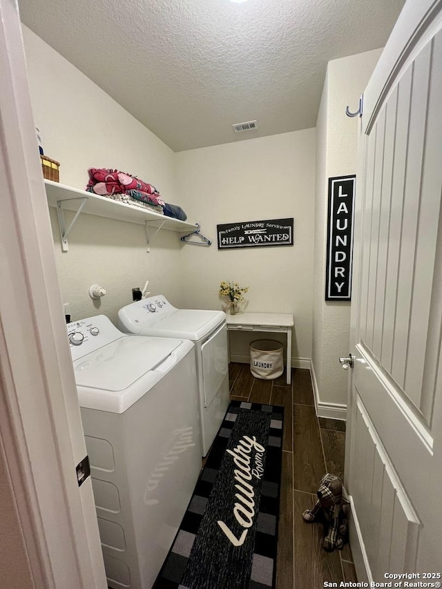 washroom with a textured ceiling and washing machine and clothes dryer