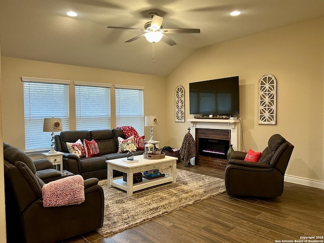 living room with lofted ceiling, dark hardwood / wood-style floors, a wealth of natural light, ceiling fan, and a fireplace