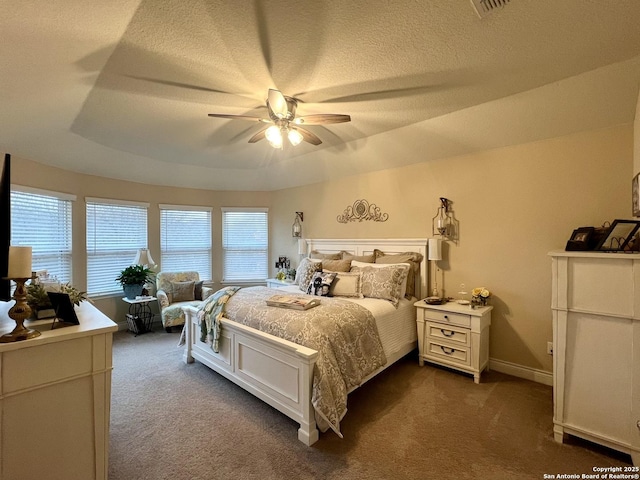 carpeted bedroom featuring a raised ceiling, a textured ceiling, and ceiling fan