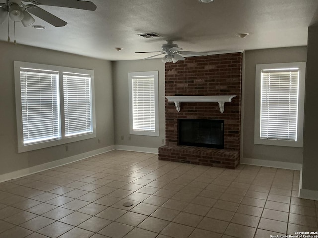 unfurnished living room featuring a brick fireplace, ceiling fan, and light tile patterned flooring