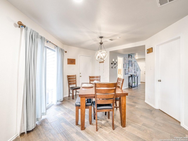 dining area featuring light hardwood / wood-style floors and a notable chandelier