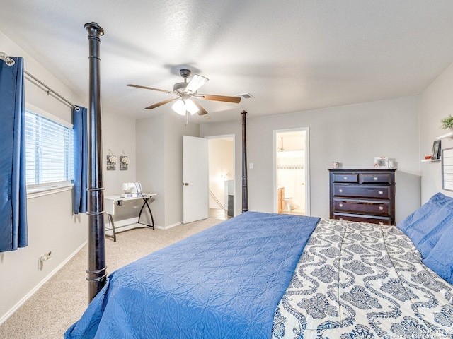 bedroom featuring ceiling fan, connected bathroom, light carpet, and a textured ceiling