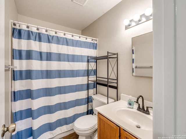 bathroom featuring vanity, toilet, curtained shower, and a textured ceiling