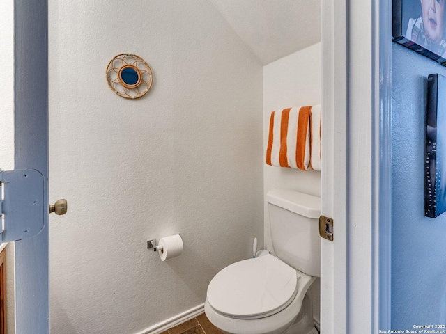 bathroom featuring lofted ceiling and toilet