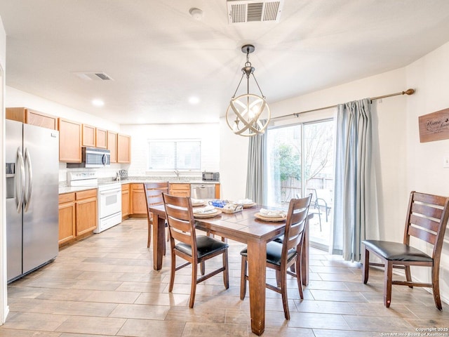 dining space featuring a notable chandelier and light hardwood / wood-style floors