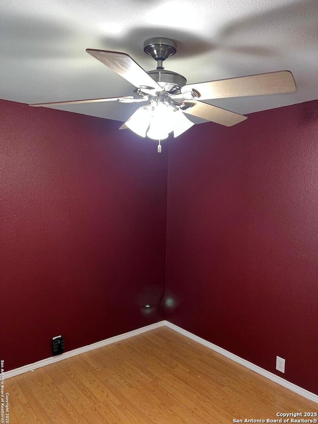 spare room featuring wood-type flooring, a textured ceiling, and ceiling fan