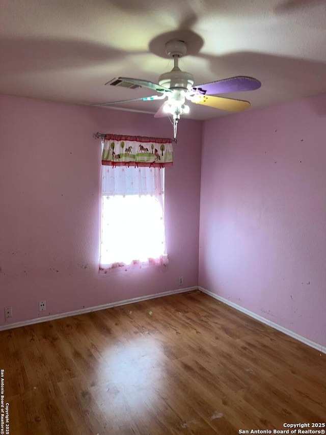 spare room featuring wood-type flooring and ceiling fan