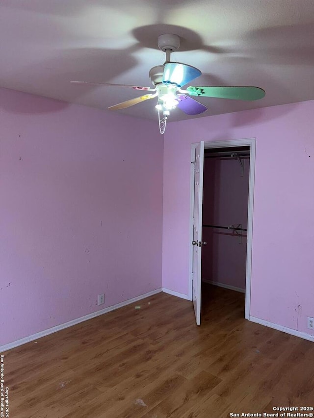 unfurnished bedroom featuring dark hardwood / wood-style flooring, a closet, and ceiling fan