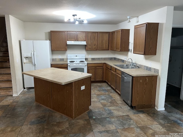 kitchen featuring white appliances, sink, a kitchen island, and a textured ceiling