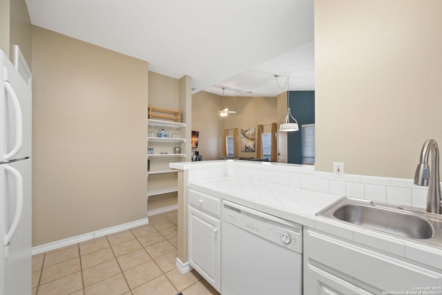 kitchen with tile countertops, decorative light fixtures, sink, white cabinets, and white appliances