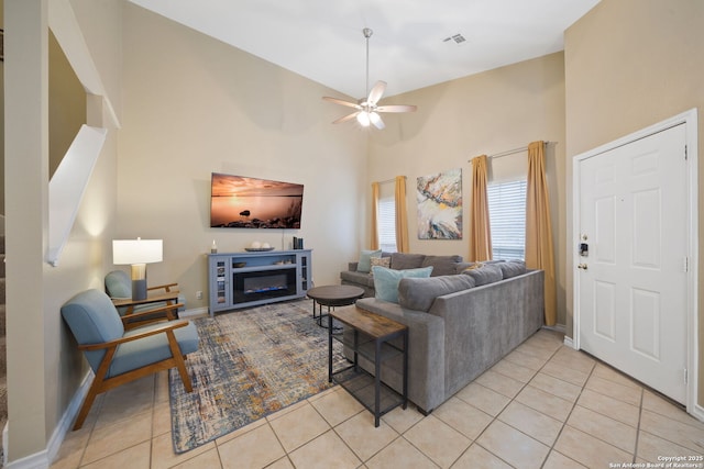 living room featuring lofted ceiling, ceiling fan, and light tile patterned flooring