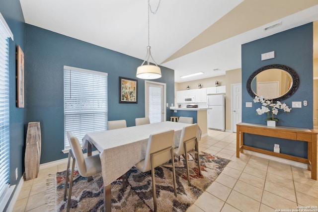 dining area with lofted ceiling and light tile patterned floors