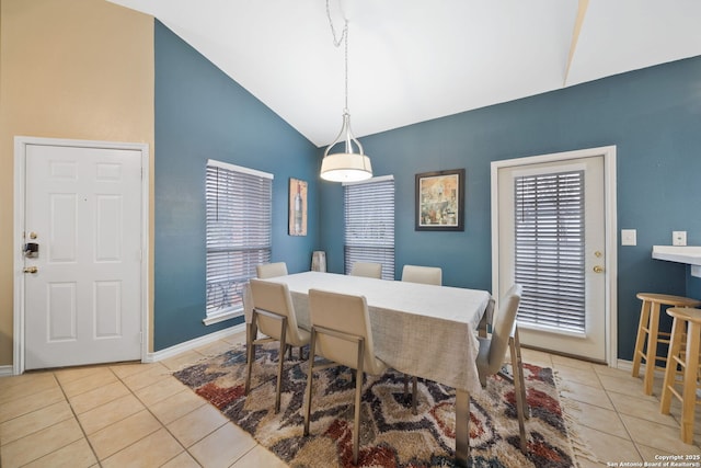 dining room with light tile patterned floors and vaulted ceiling