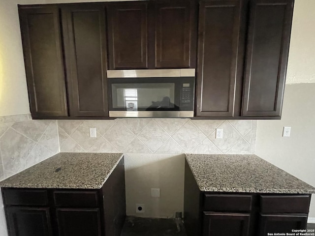 kitchen featuring light stone counters, backsplash, and dark brown cabinetry