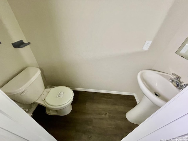 bathroom featuring wood-type flooring, sink, and toilet