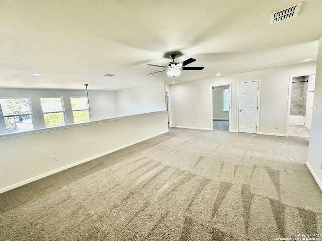 spare room featuring light carpet and ceiling fan