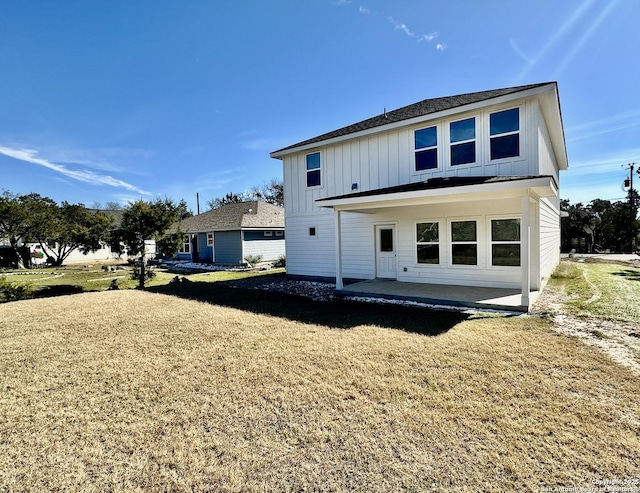 back of house featuring a patio area and a lawn