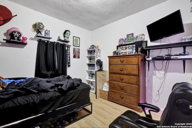 bedroom with wood-type flooring and a textured ceiling