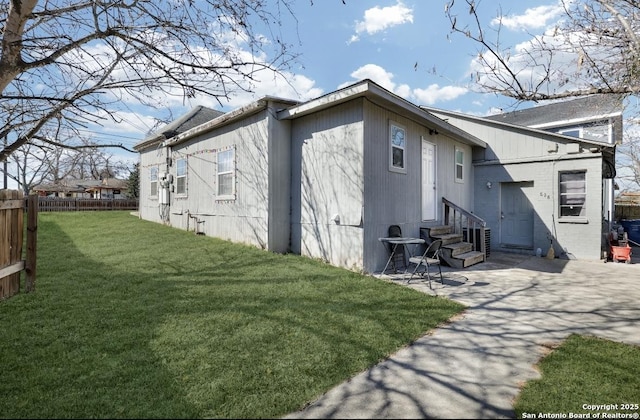 rear view of property featuring a patio and a lawn