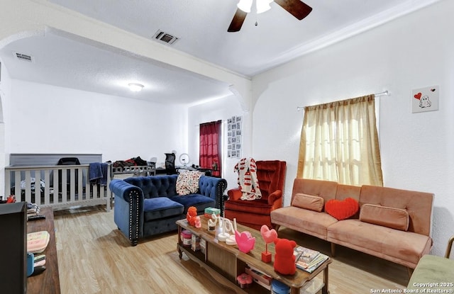 living room with hardwood / wood-style flooring, beamed ceiling, a textured ceiling, and ceiling fan