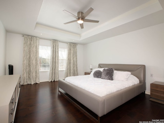 bedroom featuring crown molding, ceiling fan, dark hardwood / wood-style floors, and a raised ceiling