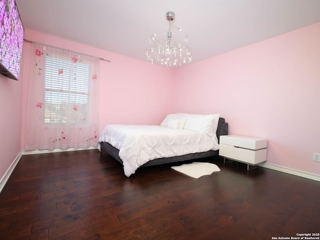 bedroom featuring dark hardwood / wood-style flooring and a chandelier