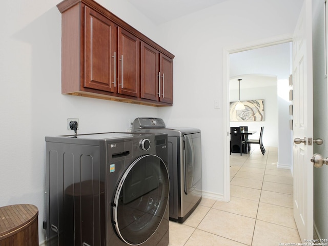 washroom with cabinets, separate washer and dryer, and light tile patterned floors