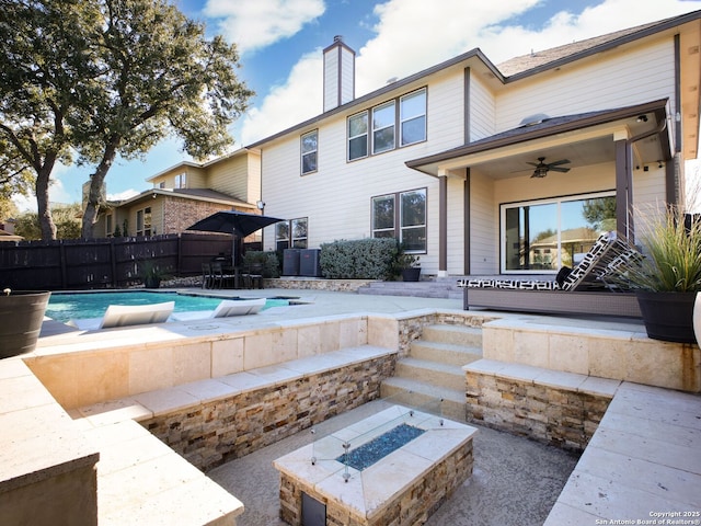 view of swimming pool with a patio, ceiling fan, and an outdoor fire pit