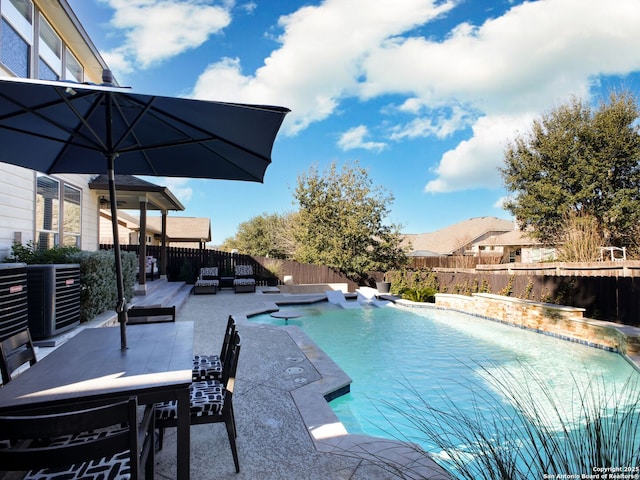 view of pool with a patio and central air condition unit