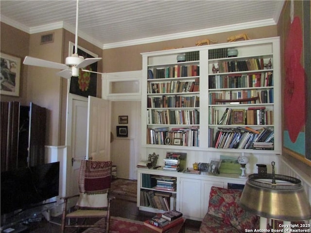 living area featuring ceiling fan and ornamental molding