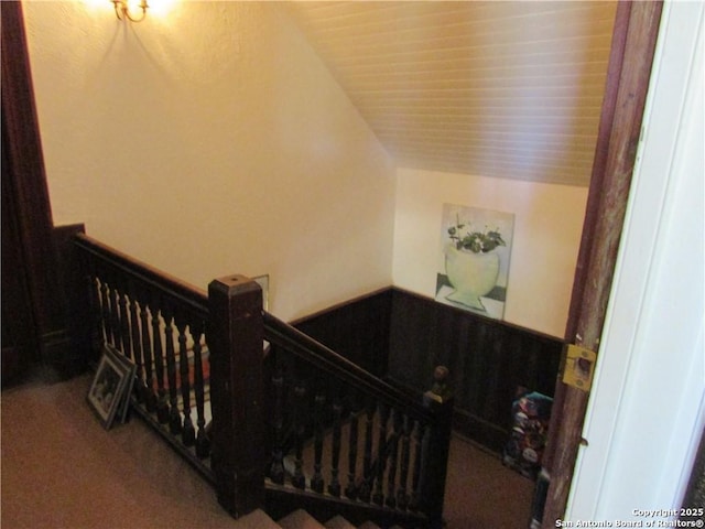 staircase featuring lofted ceiling and carpet flooring