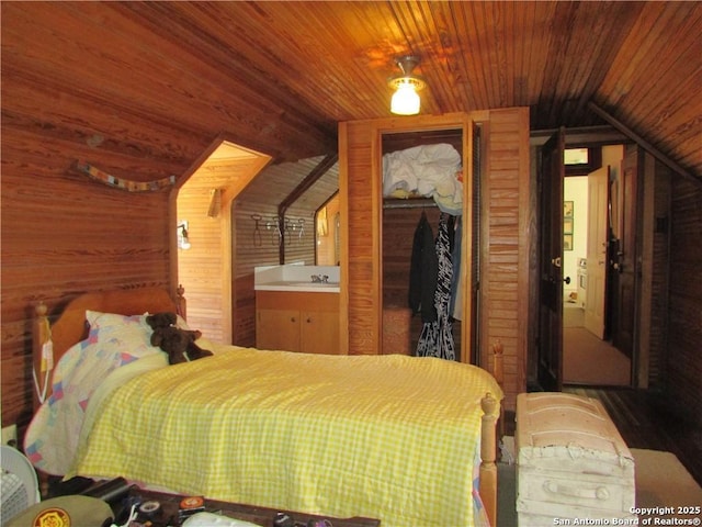 bedroom featuring vaulted ceiling, a closet, wood ceiling, and wood walls