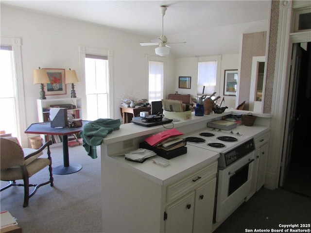 kitchen featuring ceiling fan, white electric range, kitchen peninsula, and carpet