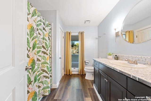 bathroom with wood-type flooring, vanity, and toilet