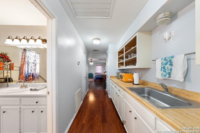 kitchen featuring white cabinetry, sink, dark wood-type flooring, and ceiling fan