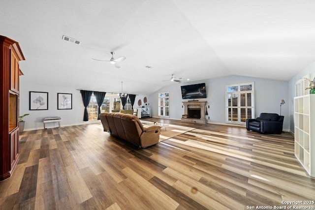 living room with ceiling fan, vaulted ceiling, and wood-type flooring