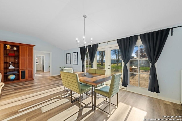 dining space with a notable chandelier, plenty of natural light, and light hardwood / wood-style floors