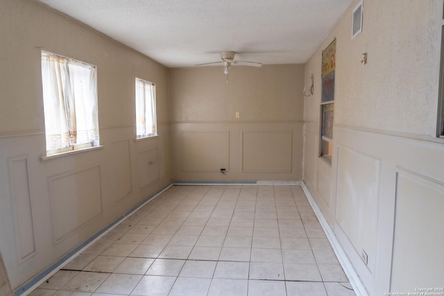 tiled spare room featuring ceiling fan and a textured ceiling