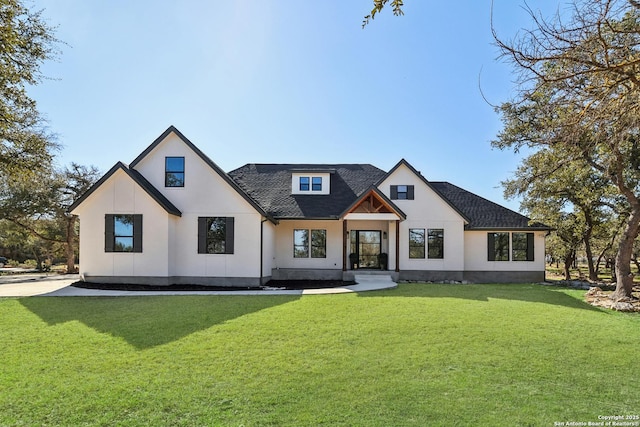 modern inspired farmhouse with a shingled roof and a front yard