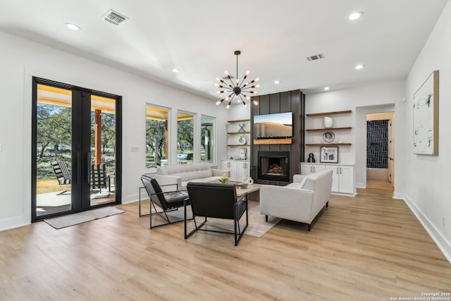 living room featuring a large fireplace, visible vents, light wood-style floors, and french doors