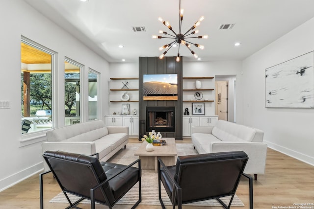 living area with light wood-style flooring, a fireplace, visible vents, and baseboards