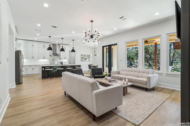 living room with recessed lighting, baseboards, visible vents, and light wood finished floors