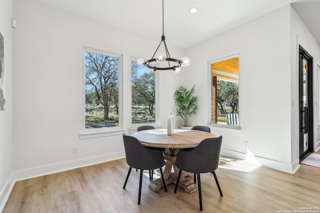 dining space featuring light wood-type flooring, baseboards, a notable chandelier, and recessed lighting