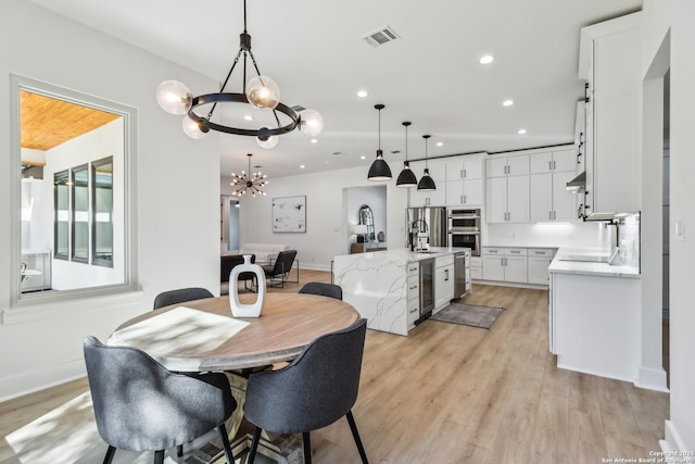 dining area with recessed lighting, visible vents, light wood-type flooring, beverage cooler, and baseboards