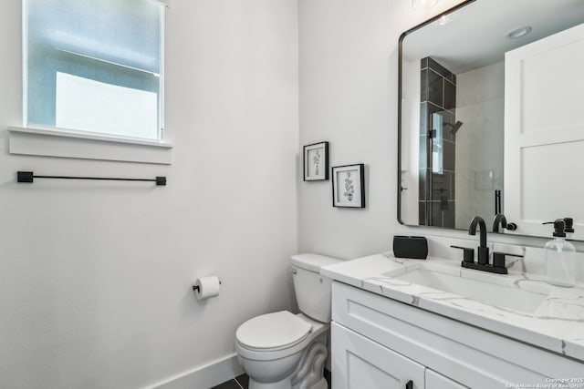 full bathroom with a stall shower, vanity, toilet, and baseboards