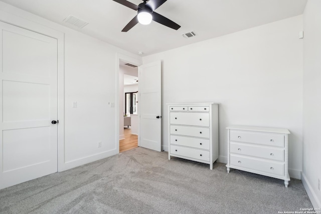 unfurnished bedroom featuring carpet floors, baseboards, visible vents, and ceiling fan