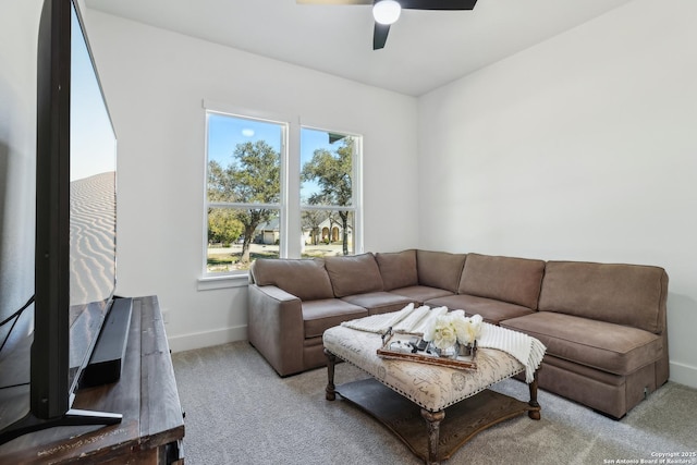 carpeted living area featuring ceiling fan and baseboards