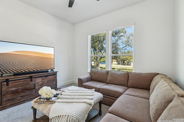 carpeted living room with ceiling fan and baseboards